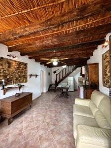 a living room with a couch and a wooden ceiling at Luby Cortijo El Horno in Lubrín