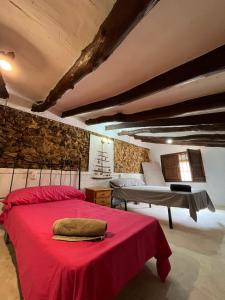 sypialnia z czerwonym łóżkiem i stołem w obiekcie Luby Cortijo El Horno w mieście Lubrín
