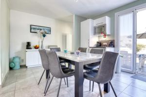 a kitchen and dining room with a table and chairs at L'Odyssée in Saint-Nic