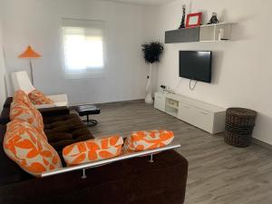 sala de estar con sofá y TV de pantalla plana en Casa Retamica en Huércal-Overa