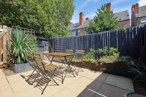 a patio with a table and chairs and a fence at Modern 2 Bed House by City Centre in Nottingham