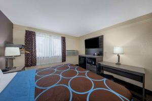 a large hotel room with a bed and a desk at Super 8 by Wyndham Kansas City at Barry Road/Airport in Kansas City