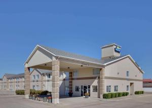 un gran edificio blanco con aparcamiento en Days Inn by Wyndham Mesquite Rodeo TX, en Mesquite