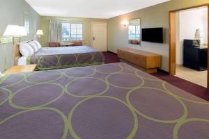 Una habitación de hotel con una cama y un televisor de pantalla plana. en Super 8 by Wyndham Crescent City, en Crescent City