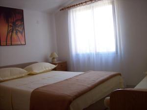 sypialnia z dużym łóżkiem i oknem w obiekcie Apartments by the sea Sevid, Trogir - 11505 w mieście Sevid