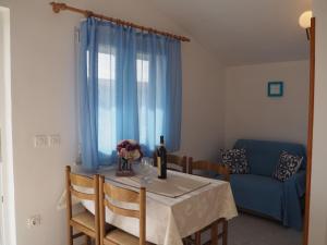 stół jadalny z niebieską zasłoną i niebieską kanapą w obiekcie Apartments by the sea Sevid, Trogir - 11505 w mieście Sevid