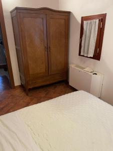 a bedroom with a bed and a wooden cabinet at Agriturismo Corte Del Brenta in Oriago Di Mira