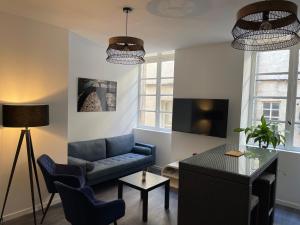 a living room with a blue couch and a table at La roue des teinturiers in Avignon