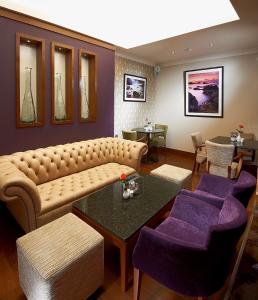 a living room with a couch and purple chairs at Best Western Moores Central Hotel in St. Peter Port