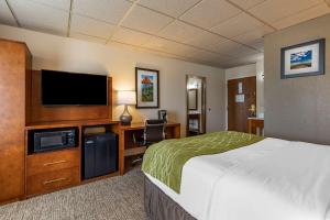 Habitación de hotel con cama y TV de pantalla plana. en Comfort Inn & Suites Gateway to Glacier National Park, en Shelby