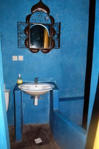 Baño azul con lavabo y espejo en Atlas Tigmi, en Ourika