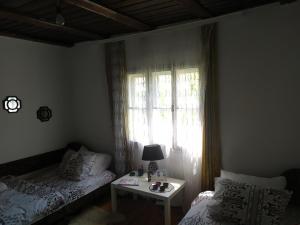 a bedroom with a bed and a table with a window at Konak Mileva in Sjenica