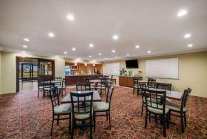 a restaurant with tables and chairs and a bar at Quality Inn & Suites - Garland in Garland