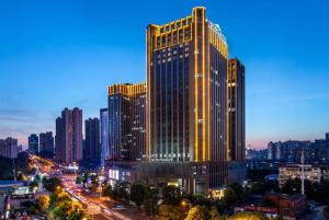 um edifício alto com luzes acesas numa cidade em Wingate by Wyndham Changsha Yuhua em Changsha