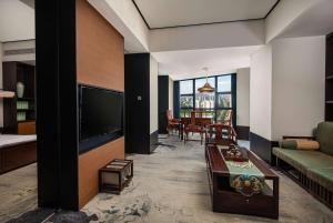 a living room with a couch and a tv at Wingate by Wyndham Changsha Yuhua in Changsha