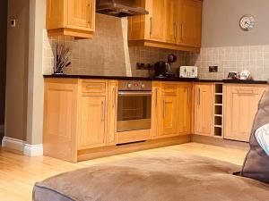 a kitchen with wooden cabinets and a stove top oven at Kingfisher Lodge, South View Lodges, Exeter in Exeter
