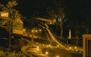 a stairway with candles on it at night at Bobocabin Gunung Mas, Puncak in Tagalbato