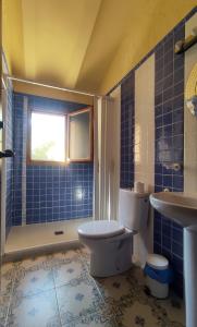 a blue tiled bathroom with a toilet and a sink at Finca La Celada in Moratalla