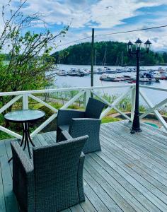 um deque de madeira com cadeiras, uma mesa e uma luz de rua em Renovated sea facing cottage on the Eidanger fjord em Porsgrunn