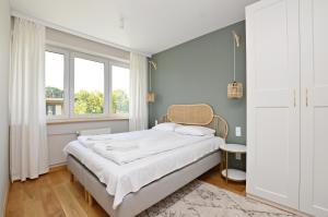Schlafzimmer mit einem Bett und einem Fenster in der Unterkunft Victus Apartamenty, Apartament Boho in Sopot