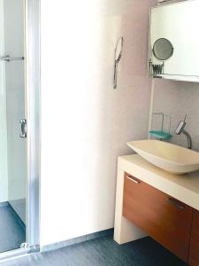 La salle de bains est pourvue d'un lavabo blanc et d'un miroir. dans l'établissement Renovated sea facing cottage on the Eidanger fjord, à Porsgrunn