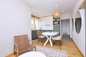 a kitchen and dining room with a table and chairs at Victus Apartamenty, Apartament Boho in Sopot