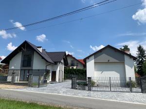 uma casa branca com uma garagem numa rua em Cozy 2-bedroom vacation apartment with entire top floor em Gaj