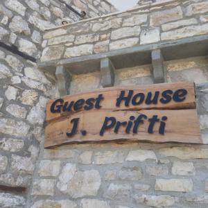 um sinal que lê a casa de hóspedes J mesmo numa parede de tijolos em Guest House J.Prifti em Berat