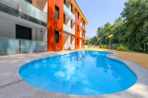 una gran piscina azul junto a un edificio en Apartamentos El Retiro de Avellaneda by RetiroRural en Arenas de San Pedro