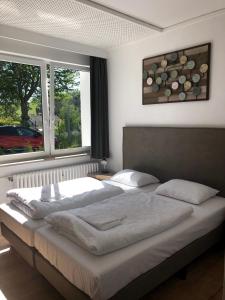 ein Schlafzimmer mit einem großen Bett und zwei Fenstern in der Unterkunft Alte Schule Züschen-Winterberg in Winterberg