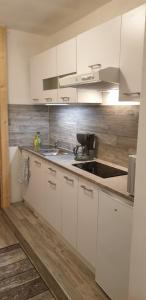 a kitchen with white cabinets and a sink at Nummer 13 - Altstadthaus in Petershagen