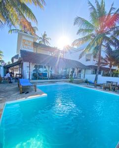 einen Pool vor einem Hotel mit Palmen in der Unterkunft Villa Thamani Zanzibar in Pwani Mchangani