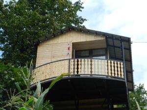 a tree house with a balcony on top of it at Cottage house in K'eda