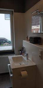 La salle de bains est pourvue d'un lavabo et d'une fenêtre. dans l'établissement Nummer 13 - Altstadthaus, à Petershagen