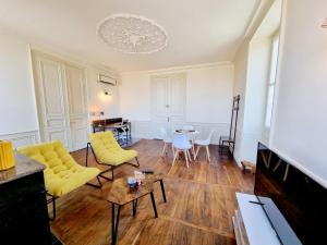 uma sala de estar com cadeiras amarelas e uma mesa em Superbe T2 lumineux avec fibre em Angoulême
