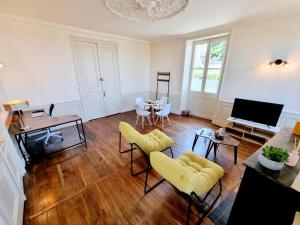 uma sala de estar com uma televisão e uma mesa e cadeiras em Superbe T2 lumineux avec fibre em Angoulême