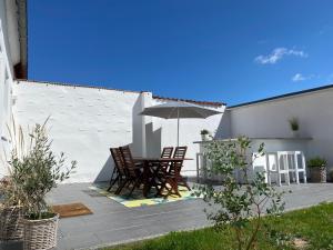 eine Terrasse mit einem Tisch, Stühlen und einem Sonnenschirm in der Unterkunft HYGG INN Ferienhaus in Heiligendamm