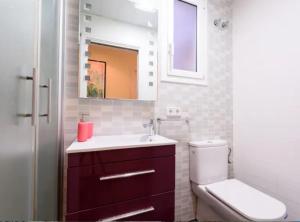 a bathroom with a toilet and a sink and a mirror at RamblasRentals Cozy Renovated 2BR with Balcony Lift 20M Rambla - Parking - Wifi in Barcelona