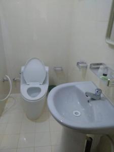 Hotel Yelona في كيجالي: حمام به مرحاض أبيض ومغسلة