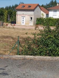 einen Zaun vor einem Feld mit einem Haus in der Unterkunft Maisonnette 40 m2 pour 5 personnes in Paray-le-Monial