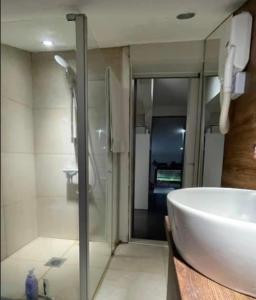 a bathroom with a glass shower and a sink at Apartman Uma in Sarajevo