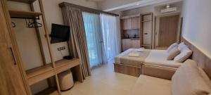 a bedroom with two beds and a television in a room at Pantheon Sea View in Nei Poroi