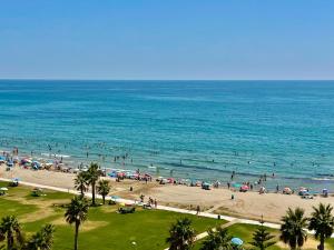 a group of people on a beach with umbrellas at Ático frente al mar. Apartamento TOP in Oropesa del Mar +20 photos
