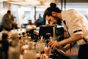 Ein Mann bereitet einen Drink an einer Bar vor. in der Unterkunft Schützen Steffisburg in Thun