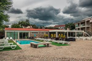 um pátio com uma piscina e cadeiras e um edifício em Casas Campo Cimo da Quinta em Miranda do Douro