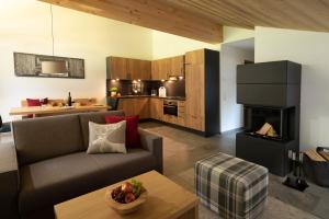 a living room with a couch and a kitchen at ArlbergResort Klösterle in Klösterle am Arlberg