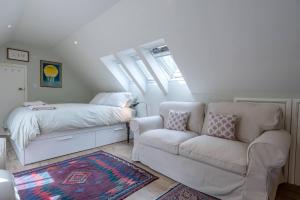 伍德布里奇的住宿－Poplar Farm Cartlodge Earl Soham Air Manage Suffolk，一间卧室配有沙发和一张带天窗的床。