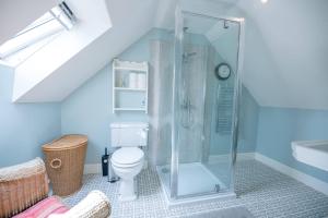 a bathroom with a toilet and a glass shower at Poplar Farm Cartlodge Earl Soham Air Manage Suffolk in Woodbridge