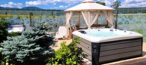a hot tub in a garden with a gazebo at Dworek Góralski in Łodygowice