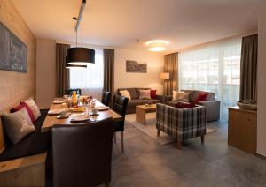 a living room with a dining table and a living room at ArlbergResort Klösterle in Klösterle